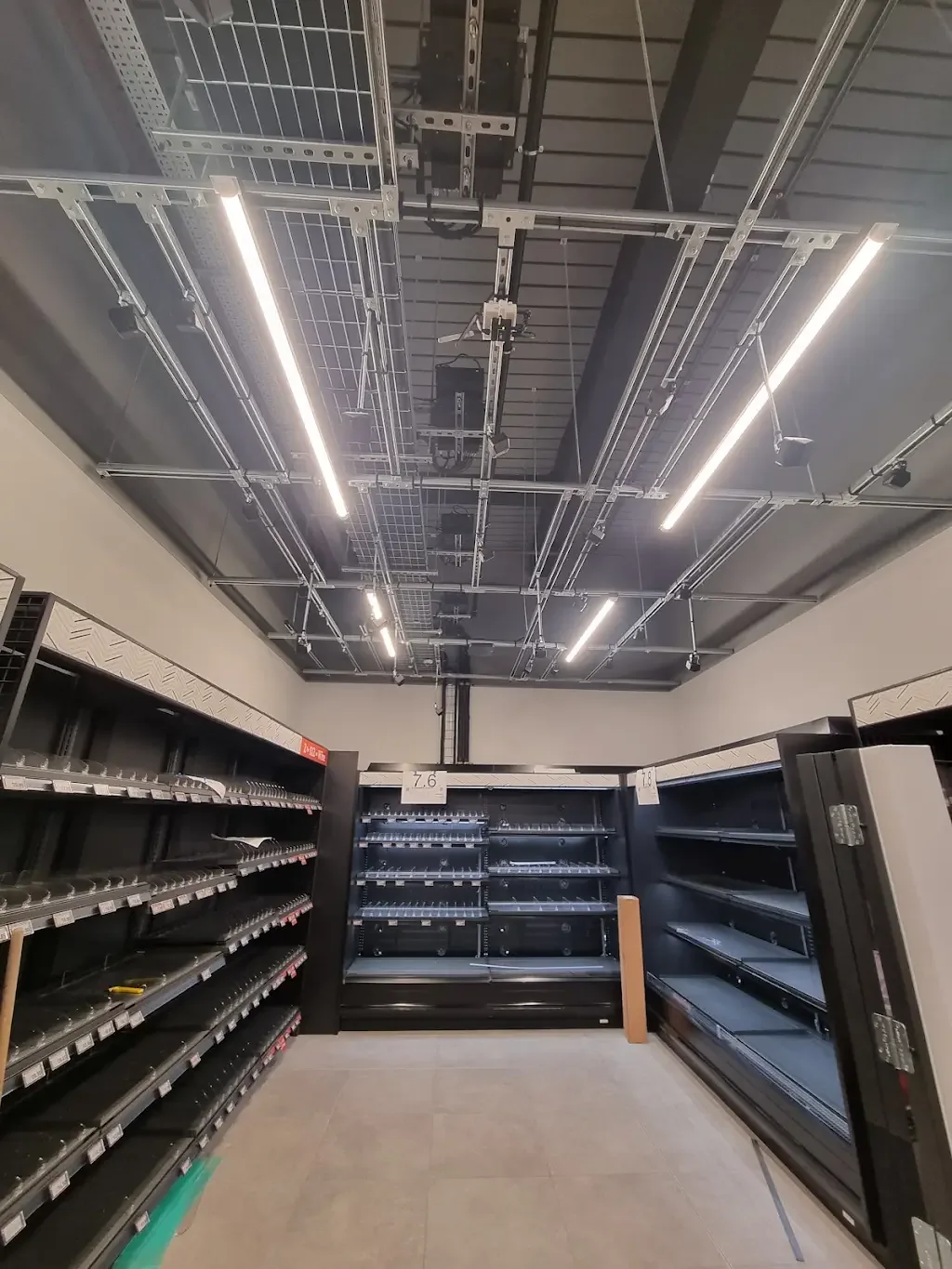 Retail refrigeration area with exposed containment and linear lighting